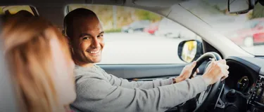 Dieses Bild zeigt einen Mann, der am Steuer eines Autos sitzt.