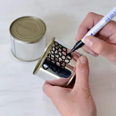 Schritt 1: Das Bild zeigt, wie Etiketten losgelöst und die Dosen bemalt werden.