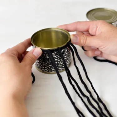 Schritt 3: Das Bild zeigt, wie Wollstränge weiterverarbeitet werden, um die Dosen später aufzuhängen.