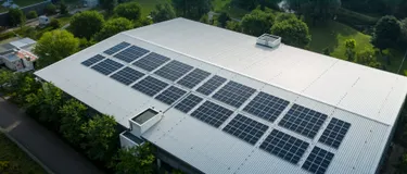 Photovoltaik: Grüner Strom direkt vom Parkhausdach. Das Bild zeigt eine Photovoltaikanlage, die auf einem Dach montiert ist.