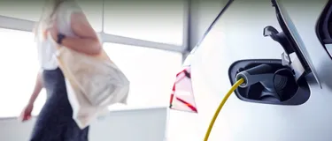 E-Auto am Arbeitsplatz laden. Dieses Bild zeigt den Ladeadapter eines Elektroautos, welches gerade geladen wird.