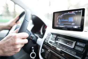 Eine Person sitzt am Steuer eines E-Autos.