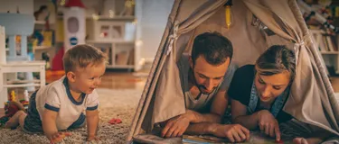Fernwärme - umweltfreundlich und effizient: Das Bild zeigt eine junge Familie, spielend im Kinderzimmer.