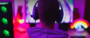 Green Gaming: Stromverbrauch bei PC & Konsolen senken. Das Bild zeigt einen jungen Mann, der gerade am Computer zockt.