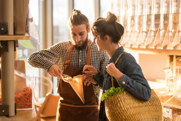 Eine junge Frau geht in einem Unverpacktladen einkaufen