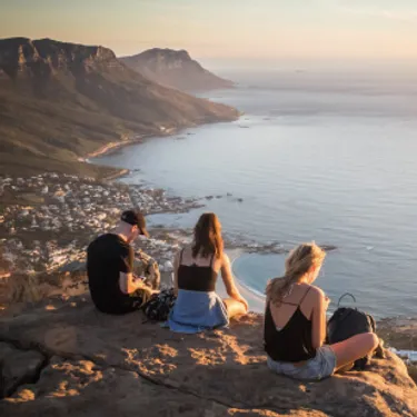 Die grünsten Städte der Welt: Kapstadt, Südafrika. Das Bild zeigt junge Menschen auf einer Erhöhung vor der Küste Kapstadts.
