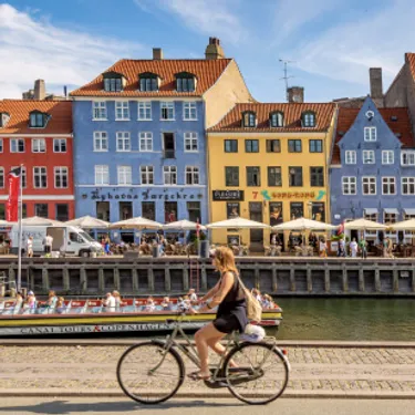 Die grünsten Städte der Welt: Kopenhagen, Dänemark - die Stadt der Radfahrer. Das Bild zeigt eine Frau auf dem Fahrrad.
