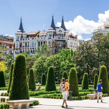 Die grünsten Städte der Welt: Madrid, Spanien. Das Bild zeigt ein Gebäude in Madrid mit einer parkähnlichen Anlage im Vordergrund.