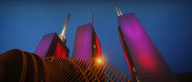 Dieses Bild zeigt das Kraftwerk von Linden aus der Froschperspektive. Die drei Türme sind pink erleuchtet.