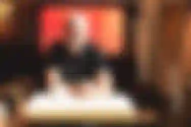 Erfahrung mit Photovoltaik. Dieses Bild zeigt einen Mann, der an einem Tisch sitzt, auf dem eine Tasse steht. Seine Hände hat er ineinander gefaltet.