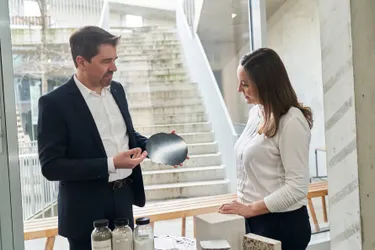 Das Bild zeigt Prof. Michael Haist, der Chefredakteurin Tanja Requardt verschiedene Betonsorten vorstellt.