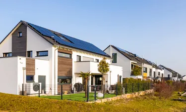 Blick über eine Reihenhaussiedlung, in der alle Häuser mit einer PV-Anlage auf dem Dach ausgestattet sind.