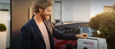 KfW-Förderung für private Wallbox und Ladestation. Das Bild zeigt einen Mann, der sein Auto an einer enercity Ladesäule lädt.