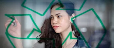 Was ist Kreislaufwirtschaft und warum ist sie so wichtig? Das Bild zeigt eine junge Frau, die das Symbol für Kreislaufwirtschaft skizziert.