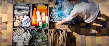 Klimaschutz und richtige Mülltrennung: Das Bild zeigt einen Menschen von oben bei der klassischen Mülltrennung.