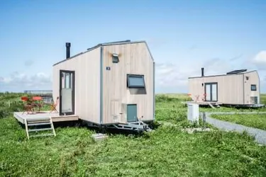 Wohnkonzepte der Zukunft: Das Bild zeigt ein TinyHouse stehend auf einer Wiese.