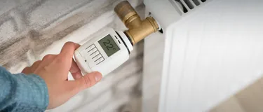 Dieses Bild zeigt ein digitales Thermostat an einem Heizkörper, auf dem die Gradzahl digital angezeigt wird.