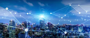 Smart City. Dieses Bild zeigt eine Stadt mit vielen Wolkenkratzern. Dieses sind alle durch Punkte und Striche miteinander vernetzt.