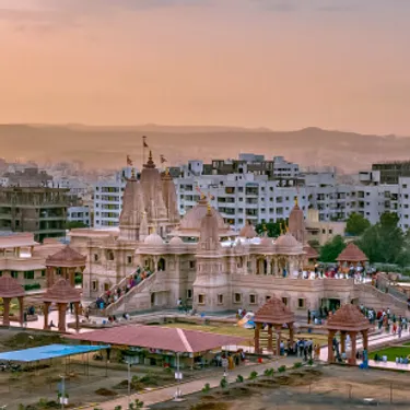 Pune. Dieses Bild zeigt einen Ausschnitt deer Stadt Pune in Indien. Im Hintergrund sind viele Hochhauser zu sehen und im Vordergrund ein größeres Gebäude.