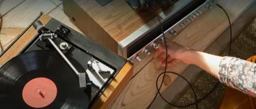 Stromverbrauch im Standby Modus: So viel Energie fressen die Geräte. Das Bild zeigt eine HiFi-Anlage, die von einer Hand bedient wird.