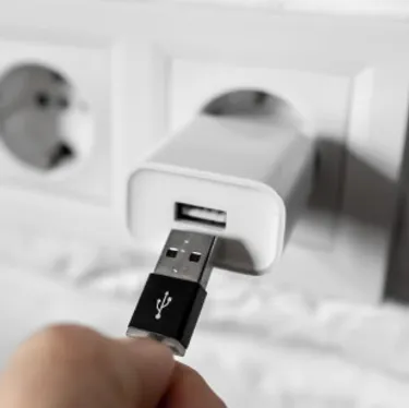 Ladegeräte, die in der Stechdose gelassen werden, verbrauchen auch Strom. Das Bild zeigt einen USB-Ladeadapter in einer Steckdose.