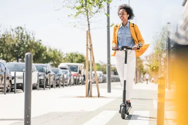 Das Bild zeigt eine junge Frau auf einem E-Scooter.