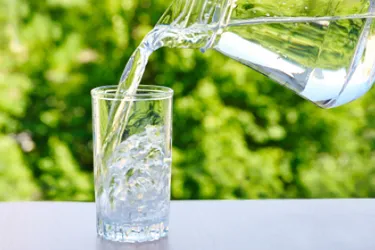 Strenge Anforderungen. Dieses Bild zeigt ein Glas, in welches mit einer Karaffe Wasser eingegossen wird.