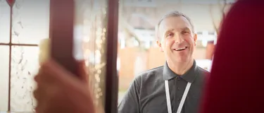 Trickbetrüger: Ihre Maschen und Tricks. Das Bild zeigt einen Mann, dem die Tür geöffnet wird.