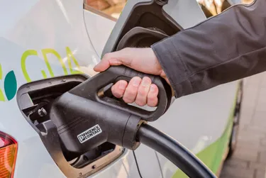 Auto laden. Dieses Bild zeigt ein Elektroauto, welches gerade geladen wird.