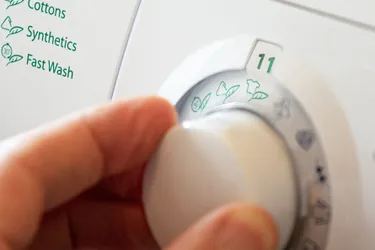 Mit dem Eco-Waschgang lässt sich Energie sparen. Das Bild zeigt eine Hand, die das Waschprogramm einer Waschmaschine auf ECO stellt.