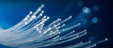 Vorteile von Glasfaserkabeln: Modernes Hintergrundbild mit leuchtenden, visualisierten Lichtleitern.