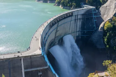 Das Bild zeigt ein Wasserspeicherkraftwerk in Form eines Staudammes. Wasser wird dabei in Seen gestaut und bei Bedarf abgelassen. Durch die Strömung werden Turbinen zur Stromerzeugung angetrieben.