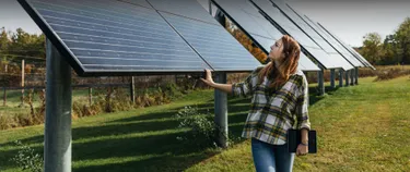 Eine Frau schaut sich eine Agri-PV-Anlage an.