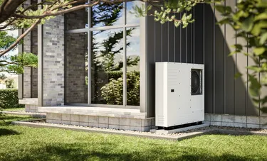 Nahaufnahme einer an einer Hauswand installierten Luft-Wasser-Wärmepumpe