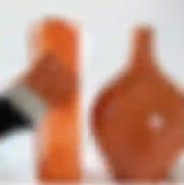 Mit einem Pinsel wird das Natron-Acrylfarben-Gemisch auf eine Vase aufgetragen.