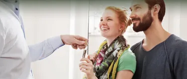 Eine Frau und ein Mann bei der Schlüsselübergabe zu ihrem Haus