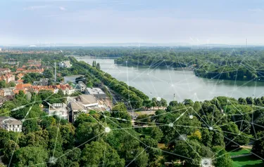 Über das Foto mit Blick über den Maschsee in Hannover wurde das Rendering eines engmaschigen Netzes gelegt, das das smarte Stromnetz darstellt.