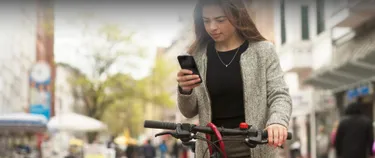 Junge Frau sucht auf dem Handy per Fahrrad-Navigations-App nach der besten Route.