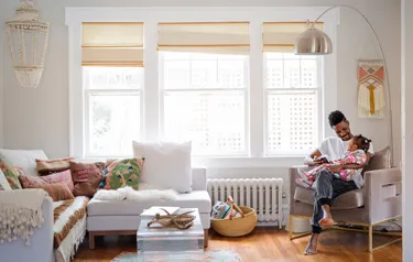 Ein Vater hält in einem Sessel sitzend seine Tochter im Arm