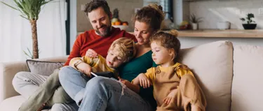 Eine Familie sitzt auf dem Sofa.