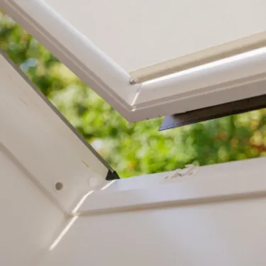 Lüften. Dieses Bild zeigt ein Dachfenster, welches einen Spalt zum Lüften geöffnet ist.