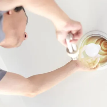 Energiesparlampen. Dieses Bild zeigt einen Mann, der eine Glühbirne in einer Lampe austauscht.