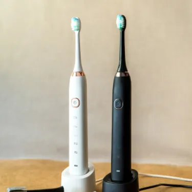 Elektrische Zahnbürsten. Dieses Bild zeigt zwei elektrische Zahnbürsten auf ihren Ladestationen.