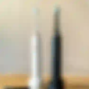 Elektrische Zahnbürsten. Dieses Bild zeigt zwei elektrische Zahnbürsten auf ihren Ladestationen.