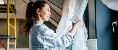 Eine Frau renoviert ein Zimmer.