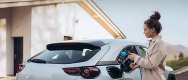 Frau tankt an der E-Ladesäule