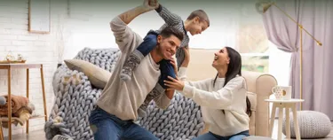 Ein Junge spielt mit seinen Eltern im Wohnzimmer