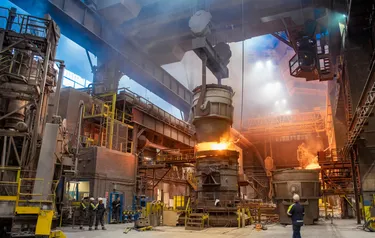 Blick in das Innere eines Stahlwerkes mit brennendem Hochofen