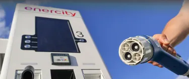 Ein Mann tankt sein E-Auto an einer Ladesäule auf.