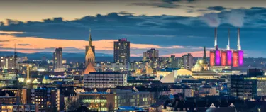 Hannover bei Nacht, im Hintergrund ist das Heizkraftwerk in den enercity-Farben pink und violett angeleuchtet.